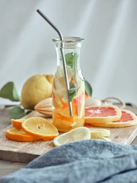 Limon portakallı, nane yapraklı ve tahta üzerinde dilimlenmiş meyveli sağlıklı limonata.