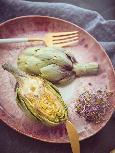 Cut Delicious Artichokes Served Plate Herbs Cutlery Table Towel Light — Stock Photo, Image
