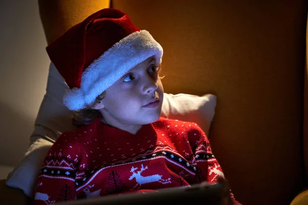 Обаятельный Мальчик Теплом Свитере Шапке Санта Клауса Расслабляющий Стол Мягком — стоковое фото