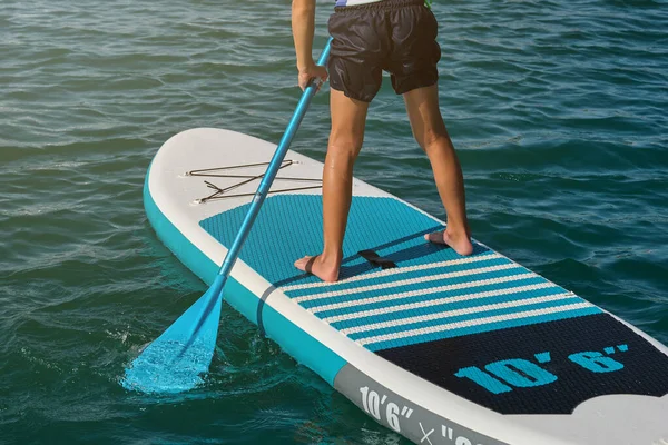 作物無名の男の子立って上のSupボードとパドリングで海の真ん中で晴れた夏の日 — ストック写真