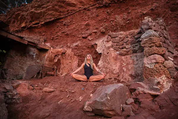 岩だらけの山でヨガを練習しながら 閉じた目で瞑想水着で若い女性のフルボディ — ストック写真