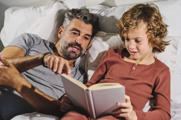 Mann Schlafanzügen Hilft Jungen Beim Lesen Interessanter Bücher Während Sich — Stockfoto