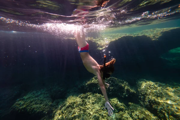 ダイビングマスクシュノーケリング中のティーンエイジャーのサイドビュー サンゴ礁で水中美を探索しながら — ストック写真