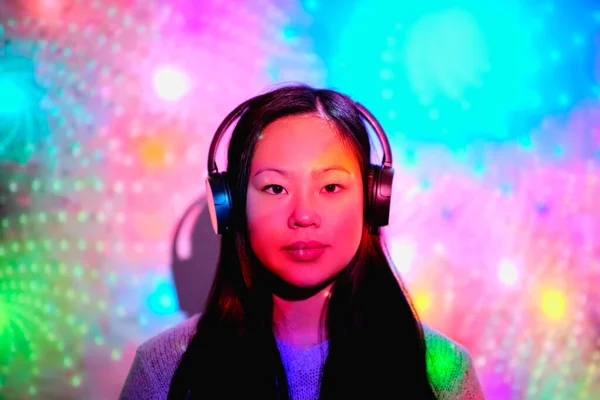 Allvarlig Asiatisk Kvinna Tittar Kameran Medan Lyssnar Musik Trådlösa Hörlurar — Stockfoto