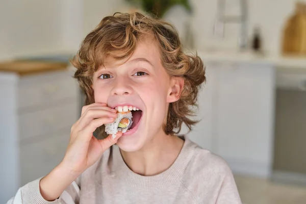Schattige Kleine Jongen Met Krullend Haar Eten Heerlijke Roll Kijken — Stockfoto
