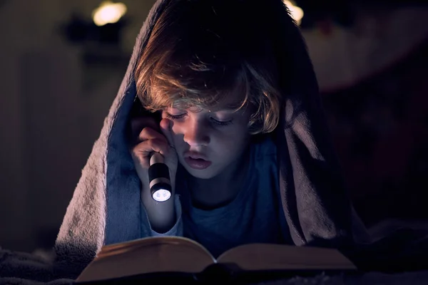 Focused Boy Reading Book Interest Shining Flashlight While Lying Bed — Stock Photo, Image