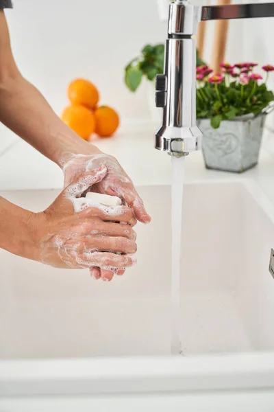 作物の側面図匿名の人が手をこすりながら バスルームシンクで洗浄するための手に石鹸を広げる — ストック写真