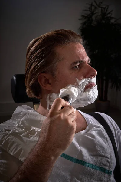 Серьезный Клиент Мужчина Белом Носит Белую Пену Бритья Бороде Сидя — стоковое фото