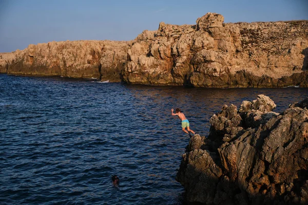 Criança Irreconhecível Trajes Banho Saltando Para Oceano Partir Borda Penhasco — Fotografia de Stock