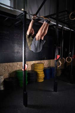 Çağdaş spor salonunda yoğun idman sırasında spor giyim alanında egzersiz yapan formda bir erkek sporcu.