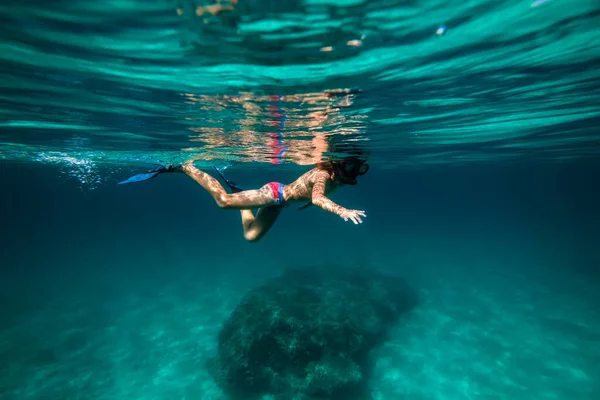 フルボディのサイドビュー 匿名のティーンエイジャーボーイフリッパーとシュノーケリングマスクで深い青い海水に浮かぶ — ストック写真