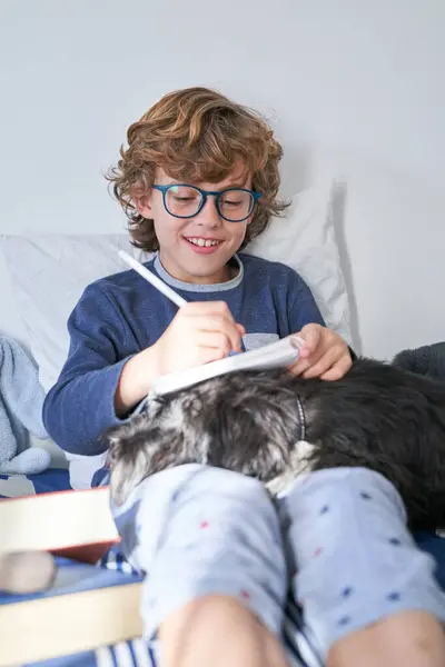 Niño Positivo Anteojos Sentado Con Perro Esponjoso Tomando Notas Cuaderno —  Fotos de Stock