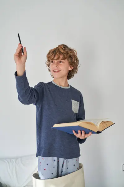 Rozkošný Chlapec Ležérní Oblečení Dívá Pryč Zatímco Drží Otevřenou Knihu — Stock fotografie