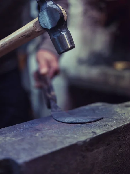 전통적인 워크샵에서 오래된 앤빌에 금속을 위조하는 망치를 사용하여 블랙스미스의 — 스톡 사진