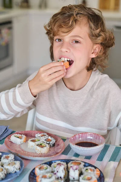 Cute Boy Curly Blond Hair Eating Delicious Sushi While Sitting — Stock Photo, Image