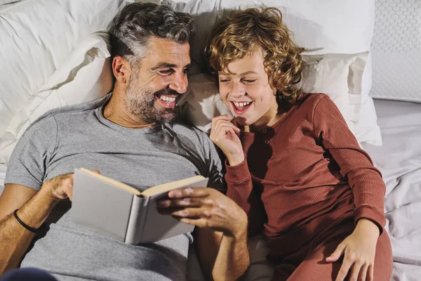 Góry Szczęśliwy Ojciec Syn Piżamie Bawiąc Się Czytając Ciekawe Książki — Zdjęcie stockowe