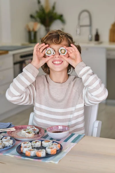 Preteen Child Smiling Putting Sushi Eyes While Sitting Table Plate — Stock Photo, Image
