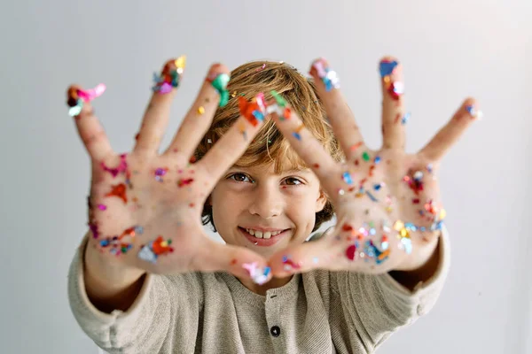 Pozitivní Chlapec Ukazuje Dlaně Barevnými Konfety Při Zábavě Párty Při — Stock fotografie