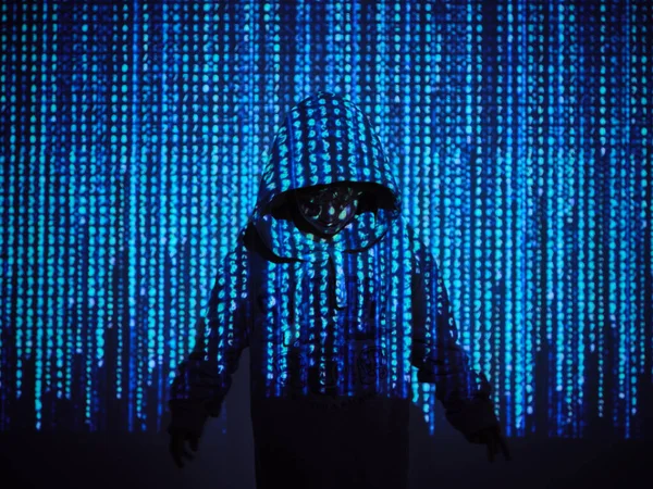 Анонимный Хакер Толстовке Стоящий Проекции Синего Двоичного Кода Темной Комнате — стоковое фото