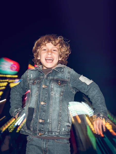 Счастливый Мальчик Повседневной Одежде Смотрит Камеру Время Прыжка Возле Освещенного — стоковое фото