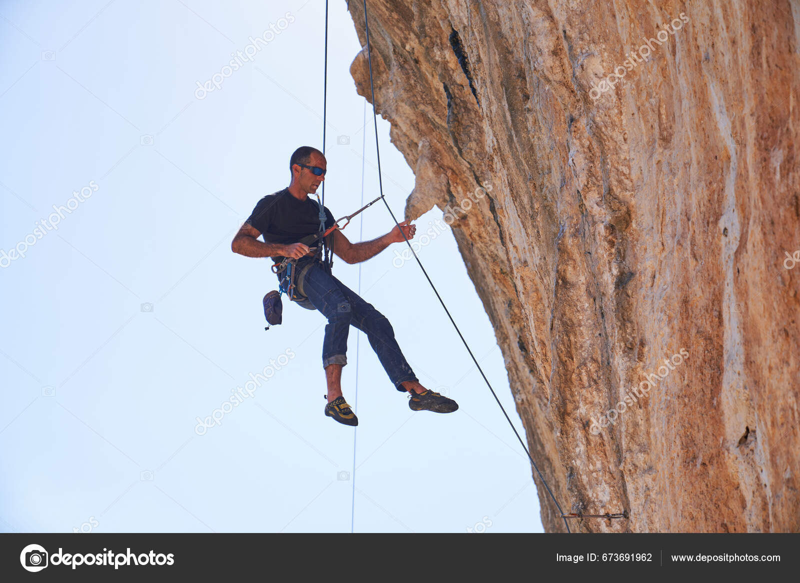 Full Body Side View Male Alpinist Hanging Rope While Descending