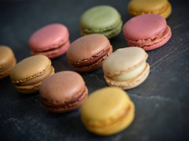 Tatlı dolgulu lezzetli yuvarlak badem kurabiyeleri ve ışık odasındaki gri masada farklı aromalar.