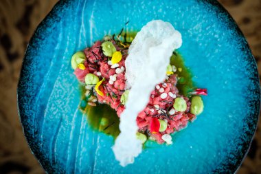 Lokantada tabakta karides krakeriyle servis edilen wasabi ile süslenmiş lezzetli kırmızı ton balıklı tartar.