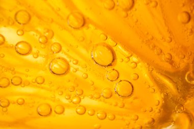 Taze portakal dilimli, nefis, şeffaf alkollü cin ve tonik karışımlı, aydınlatma odasında küçük kabarcıklar olan tam kare.