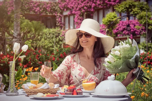 在阳光灿烂的日子里 快乐的女人在花园里喝着香槟酒的照片 — 图库照片
