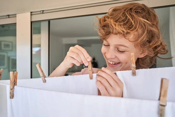 Adorable Smiling Positive Curly Haired Boy Using Wooden Clothespins Hanging — Stock Photo, Image