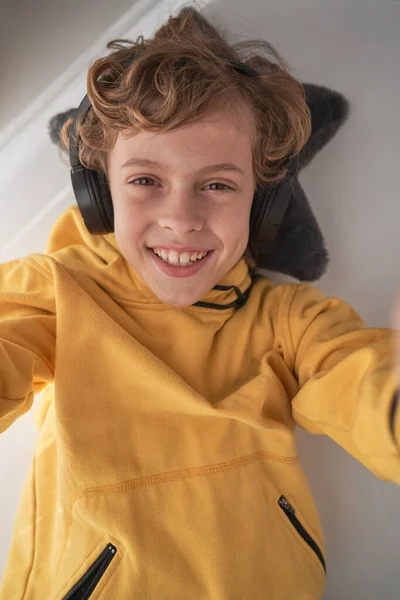 Widok Góry Zachwycony Nastolatek Żółtej Bluzie Słuchawki Bezprzewodowe Słuchając Muzyki — Zdjęcie stockowe