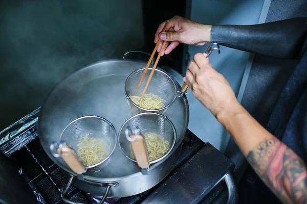 Japon Restoranının Mutfağında Tanınmamış Bir Şefin Erişte Pişirirken Çekilmiş Fotoğrafı — Stok fotoğraf