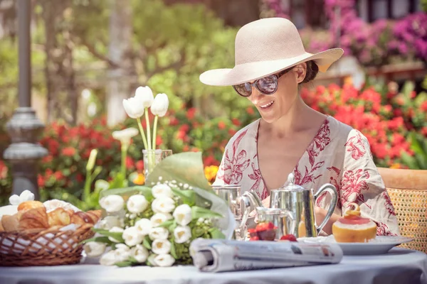 戴着太阳镜的女人在花园里享用早午餐的照片 — 图库照片