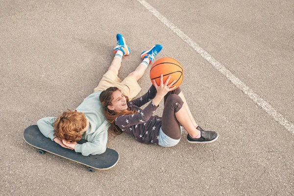 Сверху Восторженные Девочка Подросток Мальчик Баскетболом Лежал Улице Скейтборде Веселясь — стоковое фото