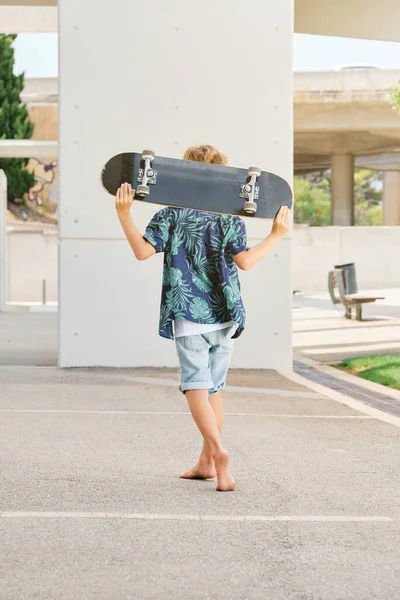 Πίσω Όψη Του Ανώνυμου Αγοριού Casual Ρούχα Που Μεταφέρουν Skateboard — Φωτογραφία Αρχείου