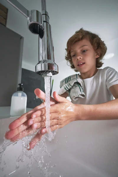 浅色浴室日常卫生习惯中 穿着休闲装 用毛巾洗手 用清水洗碗的可爱男孩 — 图库照片