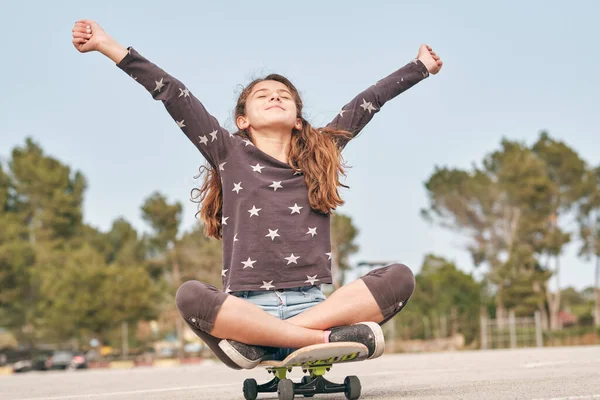 Pozemní Úroveň Šťastný Dospívající Bruslař Sedí Skateboardu Nataženými Pažemi Těší — Stock fotografie