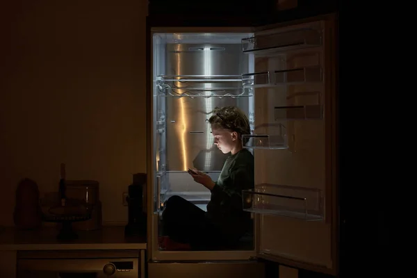 Вид Сбоку Серьезного Мальчика Повседневной Одежде Сидящего Холодильнике Скрещенными Ногами — стоковое фото