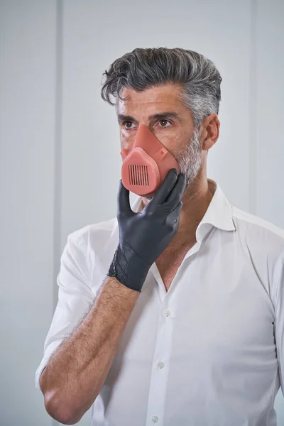 Serious Bearded Male Wearing Respirator Medical Gloves Touching Chin Preventing — Stock Photo, Image