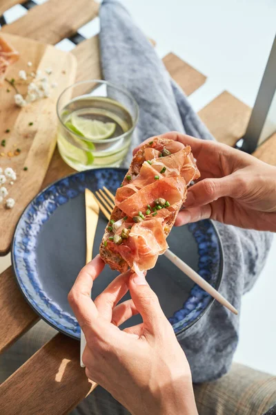 High Angle Crop Faceless Female Eating Delicious Toast Prosciutto Capers — Stock Photo, Image