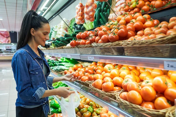 轻便超级市场购物时 带尼龙袋的女顾客从摊档中挑选新鲜西红柿的侧视图 — 图库照片