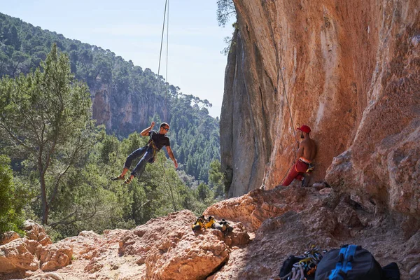 Distanzierter Bergsteiger Der Einer Felsklippe Der Nähe Eines Mannes Steht — Stockfoto