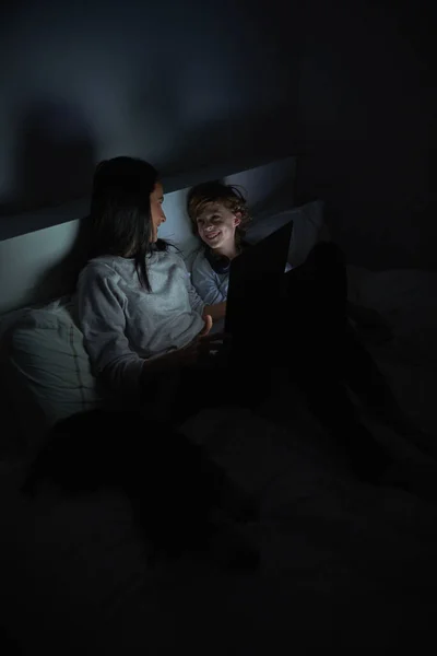 Веселая Женщина Мальчик Ночной Одежде Лежат Кровати Одеялом Ноутбуком Смотрят — стоковое фото