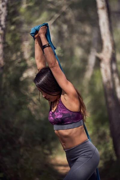 森林户外运动时穿着运动服 头戴抗拉带 头戴三头肌锻炼的年轻西班牙女运动员侧视图 — 图库照片