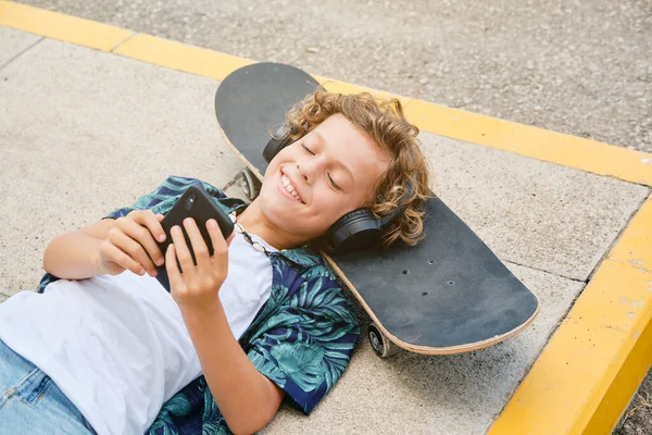 Shora Usměvavé Dítě Sluchátkách Poslech Hudby Procházení Smartphone Při Odpočinku — Stock fotografie