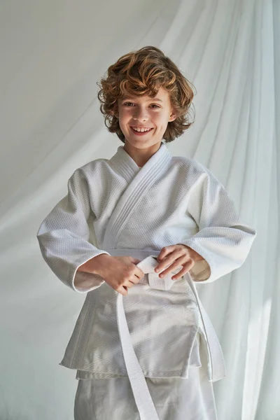 Smiling Curly Haired Boy White Kimono Standing Curtain Tying Belt — Stock Photo, Image