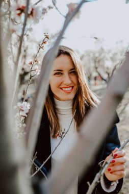 Bahçedeki ağaçların arasında mutlu bir kadın