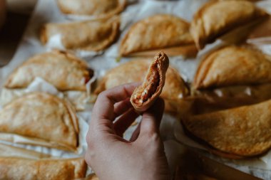 Anonim insan yemek ve pişirme tepsisi ile taze pişmiş turtalar köfte ve altın çıtır ekmek.