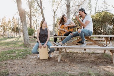 Neşeli müzisyenler parkta eğleniyor.