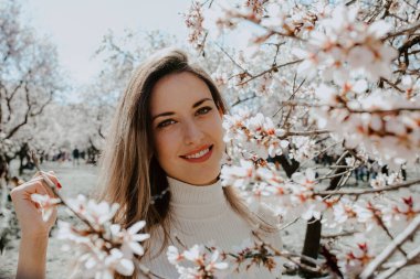 Bahçedeki ağaçların arasında mutlu bir kadın